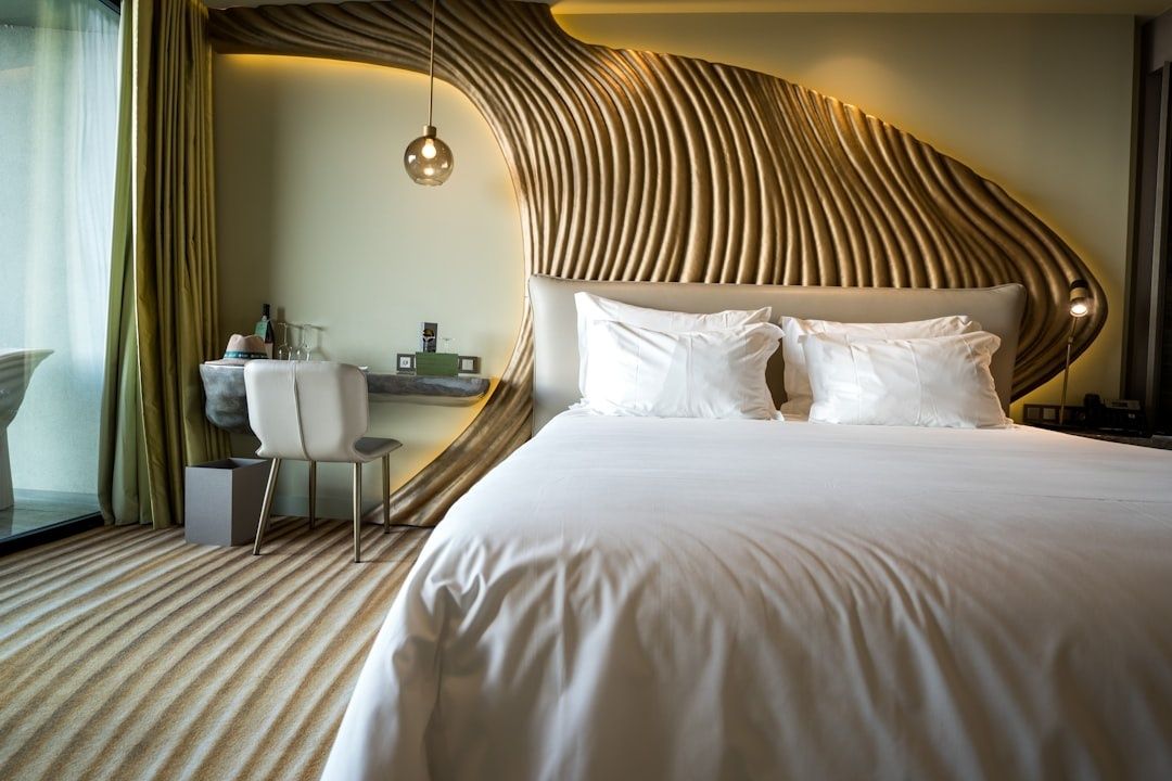 Chambre d’hôtel calme avec lit double et décoration murale ondulée
